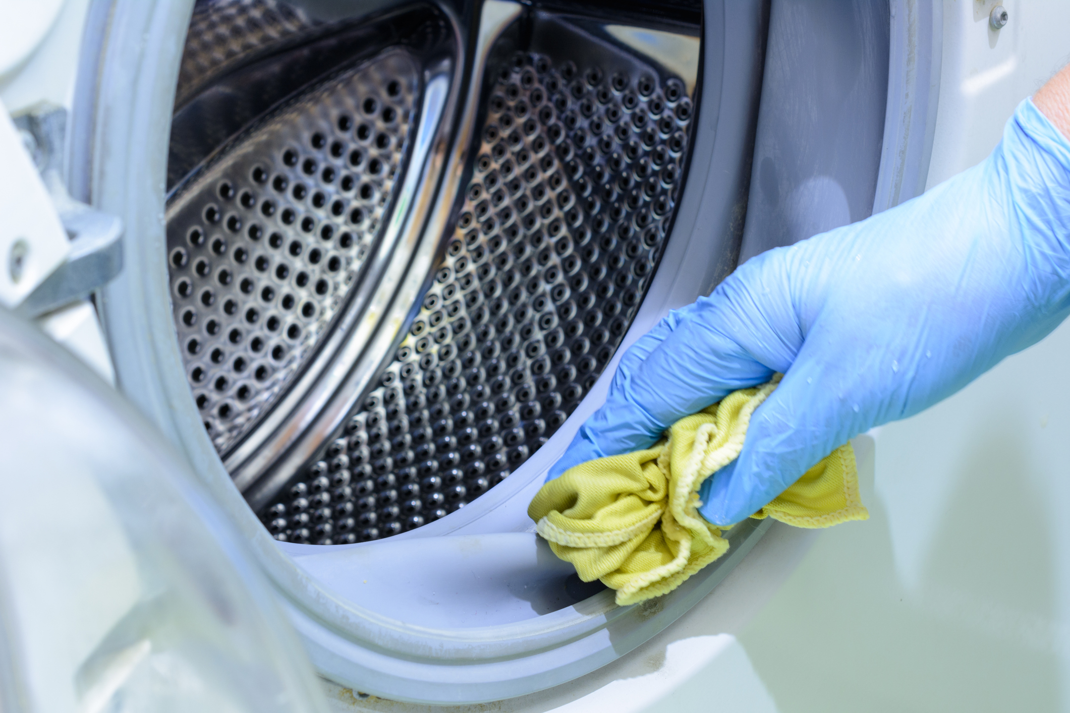 Healthcare Laundry Guidelines Wiping Down and Disinfecting Laundry Washing Machine with Rag and Rubber Gloves