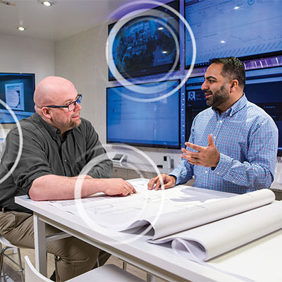 Two people reviewing technology building plans