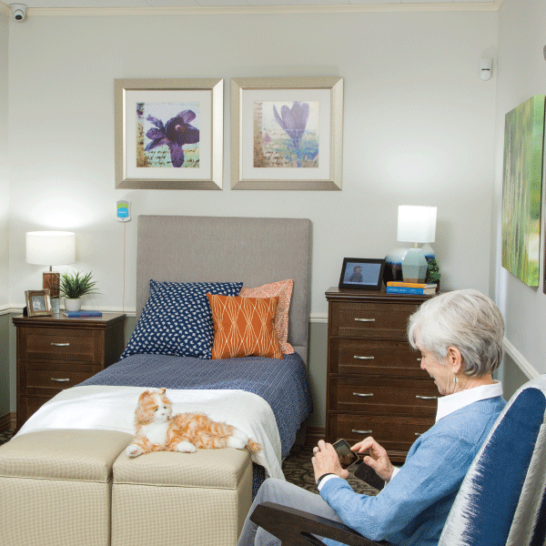 senior woman sitting in bedroom using smart phone