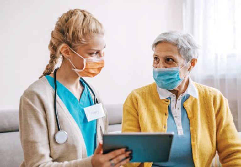 nurse showing senior woman tablet