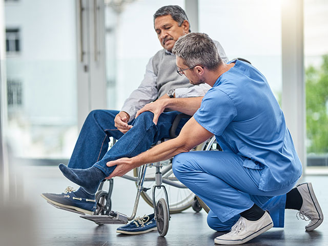 nurse helping a senior man in a wheelchair