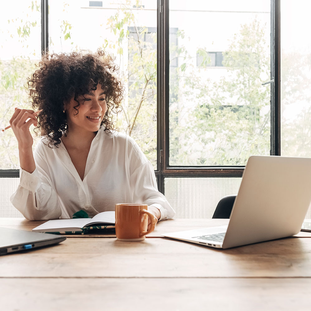 woman watching a webinar and taking notes