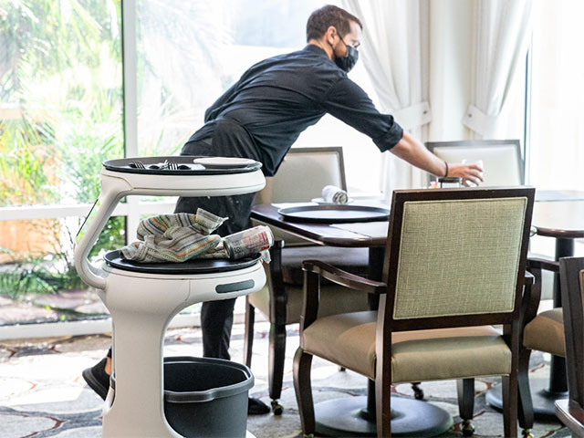 Food robot Servi bussing tables with an assisted living worker to improve Senior Living Dining