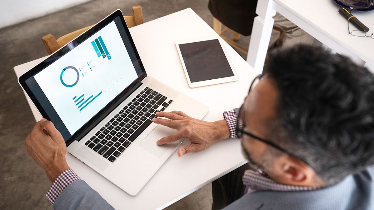 Professional man looking at report on laptop